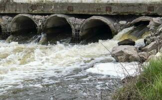 ein Beton Rohr Das trägt stinkend, verschmutzt Abwasser in das Fluss durch Rohre. Verschmutzung von das Umgebung und Wasser Körper. ökologisch Katastrophe. gefährlich Abfall Wasser. foto