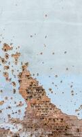 das Mauer von ein Gebäude angeschlagen durch Rakete Fragmente im ein Krieg Zone. geschält Mauer. Fassade von ein ausgebombt Gebäude. bewaffnet Konflikt im Ukraine. Beschädigung zu das Haus wie ein Ergebnis von Artillerie Beschuss. foto