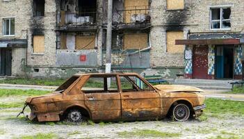 Konsequenzen von das Bombardierung im das Stadt. das Rakete blies oben das Haus. ein ausgebombt Wohnung Gebäude und ausgebrannt Autos nach ein Luftangriff. Löcher im das Wände von Muscheln. Überreste von Eigentum. foto