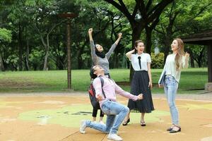 jung asiatisch malaiisch Chinesisch Mann Frau draussen Park gehen Stand Studie sich unterhalten diskutieren Punkt Laptop Datei Buch Rucksack mischen Spaß glücklich Freude Sieg foto