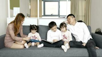 Eltern Kind Familie Vater Mutter Tochter Sohn sitzen auf Sofa lesen Schreiben Studie Lehren foto