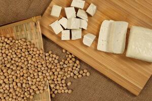 Sojabohnen Quark Tofu Soja Bohnen fließend Bambus Sieb hölzern Tafel auf Jute Hintergrund foto