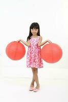 uth Osten asiatisch jung Mädchen Kind Stand Pose aussehen beim Kamera halten Chinesisch rot Papier Laterne auf Weiß Hintergrund foto