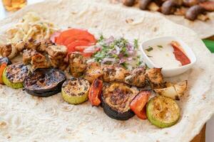 gegrillt Kebab mit Pita-Brot Brot und Gemüse auf Tablett im Sommer- schnell Essen Straße Cafe foto