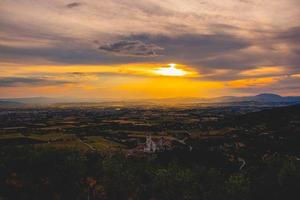 Basilika von San Francisco in Assisi mit einem herrlichen Sonnenuntergang foto