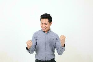 Süd Osten asiatisch malaiisch Mann Gesichts- Ausdruck glücklich verlassen Faust im das Luft foto