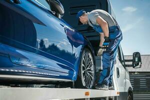 Auto Rücknahme Arbeiter Sicherung Fahrzeug auf seine Abschleppen LKW foto