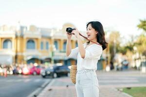 Porträt schön asiatisch Frau Reisender mit Kamera erkunden Straße auf Sommer- Ferien im Bangkok, Thailand foto