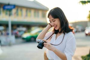 Porträt von asiatisch Frau Reisender mit Kamera beim Straße von Bangkok, Thailand. Asien Sommer- Tourismus Ferien Konzept foto