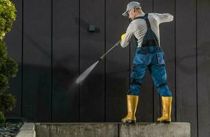 Arbeiter Reinigung modern Gebäude dunkel Mauer mit Druck Unterlegscheibe foto