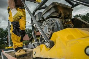 Fachmann Boden Verdichter betrieben durch Konstruktion Arbeiter foto