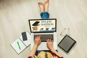 Einkaufen, Technologie und Internet Konzept jung Mädchen Einkaufen mit Laptop Computer auf ein fiktiv Geschäft foto