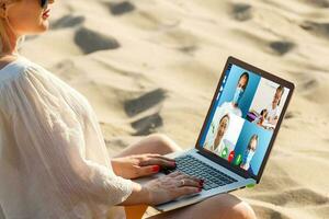 abgeschnitten Bild von jung Frau mit Laptop zum Video Konferenz beim Zuhause foto