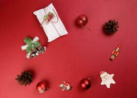 Weihnachten Weihnachten Dekoration Ornament Glocke Geschenk wickeln Stollen Obst Kuchen Essen Kiefer Obst auf rot Hintergrund foto