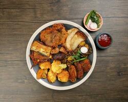 indisch Bengali Schweinestall Vielfalt Monteur tief gebraten tanpura piaju pakoda angeschlagen Blumenkohl Aubergine Knödel Chola dal braten Termine zum iftar Frühstück Snack Komfort Essen rustikal Holz Hintergrund foto