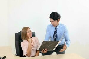 asiatisch jung Mann Frau malaiisch Chinesisch Büro zuversichtlich glücklich sitzen Stand sich unterhalten diskutieren Show Punkt sehen dokumentieren Datei Mappe foto