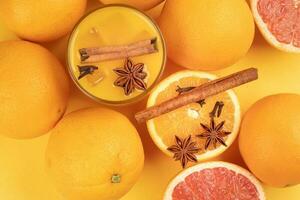 frisch Orange Zimt Star Anis Nelke würzen Saft im Glas auf Weiß Gelb Hintergrund foto