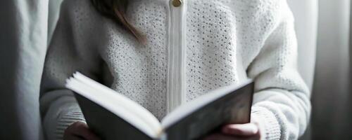 jung Mädchen im Weiß Strickjacke lesen geöffnet Buch, Wissen und Kind lesen Konzept, generativ ai foto