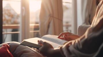 schließen oben Hand von Frau öffnen ein Buch auf Sofa im Morgen in der Nähe von Fenster, generativ ai foto