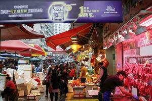 Hong Kong- März 12, 2019 überfüllt chun jeung Straße nass Markt Straßenbahn Linie und Geschäfte und Stände Verkauf Gemüse, Fleisch, Fisch, Früchte usw. foto