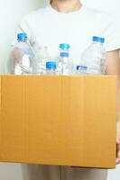 Freiwillige behalten Plastik Flasche in Papier Box beim Zuhause oder Büro. Hand Sortierung recyceln Müll. Ökologie, Umwelt, Verschmutzung, entsorgen Recycling, Abfall Verwaltung und Müll Trennung Konzept foto