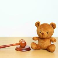 Kinder, Kind und Familie Gesetz Konzepte. Spielzeug Bär mit Hammer Gerechtigkeit Hammer auf Schreibtisch im Gerichtsgebäude. foto