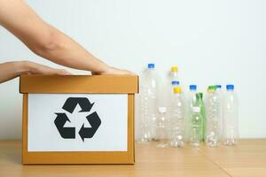 Freiwillige behalten Plastik Flasche in Papier Box beim Zuhause oder Büro. Hand Sortierung recyceln Müll. Ökologie, Umwelt, Verschmutzung, entsorgen Recycling, Abfall Verwaltung und Müll Trennung Konzept foto