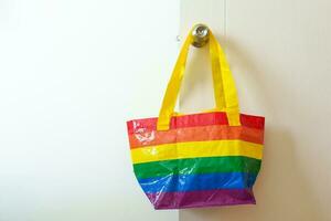 lgbt Stolz Monat Konzept oder lgbtq oder lgbtqia,öko freundlich Tasche mit Regenbogen Farbe hängend auf das Tür. foto