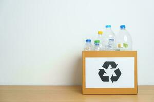 Plastik Flasche im Papier Box beim Zuhause oder Büro. recyceln Müll Sortierung. Plastik frei, Ökologie, Umwelt, Verschmutzung, entsorgen Recycling, Abfall Verwaltung und Müll Trennung Konzept foto