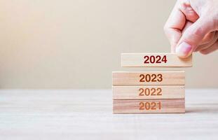 2024 Block über 2023 und 2022 Holzgebäude auf Tischhintergrund. Geschäftsplanung, Risikomanagement, Auflösung, Strategie, Lösung, Ziel, neues Jahr, neues Sie und frohe Feiertagskonzepte foto