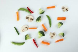 gehackt geschnitten gewürfelt Karotte Brokkoli Weiß Taste Pilz rot Chili auf Weiß Hintergrund foto