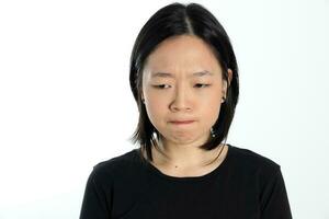 jung attraktiv Süd Osten asiatisch Frau Pose Gesicht Ausdruck Emotion auf Weiß Hintergrund denken Sorge foto