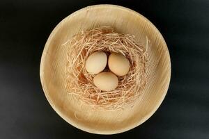 Eier im ein Nest Korb auf schwarz Hintergrund foto