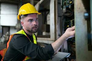 das Ingenieur inspiziert das elektrisch System und Instandsetzung das mechanisch System im das Maschine Steuerung Kabinett. im bestellen zum das Maschine zu Rückkehr zu normal Betrieb foto