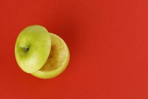 gesund Grün Schnitt Apfel schwebend oben Scheibe Saft trinken Idee Konzept auf rot Hintergrund foto