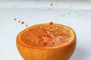 Orange echt Saft Spritzen Über frisch Hälfte Schnitt Obst foto