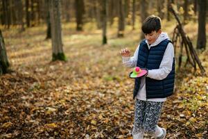 Herbst Outdoor-Porträt von Jungen spielen mit Catch-and-Toss-Ballspiel. foto