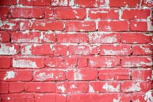 rote Backsteinmauer mit abblätternder Farbe