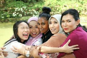 Gruppe von fünf Frau freunde malaiisch Chinesisch indisch asiatisch draussen Park See Natur umarmen Pflege Lachen glücklich foto