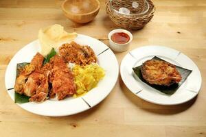 traditionell malaysisch indisch Essen Weiß Reis Kohl Gemüse Fleisch tief gebraten gehackt Hähnchen Bein gekrönt oben mit würzig mischen Soße Holz Tabelle Hintergrund foto