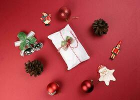 Weihnachten Weihnachten Dekoration Ornament Glocke Geschenk wickeln Stollen Obst Kuchen Essen Kiefer Obst auf rot Hintergrund foto