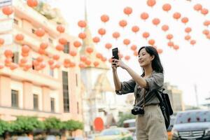 jung asiatisch Frau Rucksack Reisender genießen China Stadt, Dorf Straße Essen Markt im Bangkok, Thailand. Reisender Überprüfung aus Seite Straßen. foto