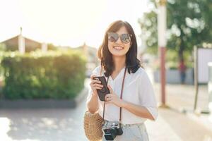 Porträt jung schön Frau mit Kamera erkunden Straße auf Sommer- Ferien im Bangkok, Thailand foto