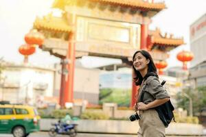 jung asiatisch Frau Rucksack Reisender genießen China Stadt, Dorf Straße Essen Markt im Bangkok, Thailand. Reisender Überprüfung aus Seite Straßen. foto