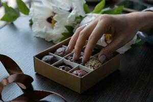 Schokolade Kunst Süßigkeiten im weiblich Hand und Süßigkeiten Box foto