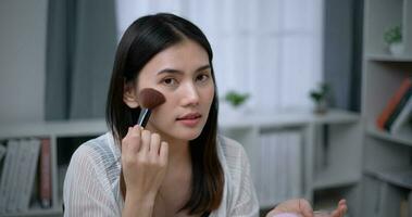 schön jung asiatisch Frau Blogger zeigt an Wie zu machen oben und verwenden Kosmetika foto