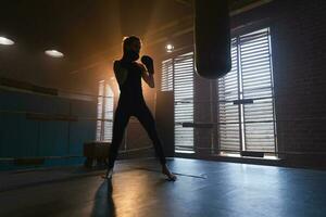 Frauen selbst Verteidigung Mädchen Leistung. stark Frau Kämpfer Ausbildung Schläge auf Boxen Ring. gesund stark Mädchen Stanzen Boxen Tasche. Ausbildung Tag im Boxen Fitnessstudio. Stärke passen Körper trainieren Ausbildung. foto