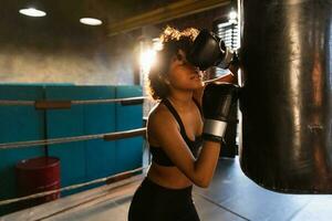 Frauen selbst Verteidigung Mädchen Leistung. afrikanisch amerikanisch Frau Kämpfer ruhen nach Kampf Ausbildung auf Boxen Ring. Mädchen müde nach Stanzen Boxen Tasche. Ausbildung Tag im Fitnessstudio, Stärke passen Körper trainieren Ausbildung foto