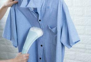 ein Frau Bügeln Kleider mit Dampf Eisen foto
