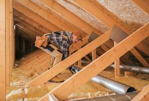 männlich Auftragnehmer installiert Metall Rohr System im Dachgeschoß. foto